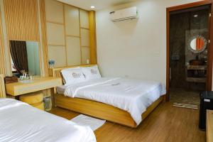 a hotel room with two beds and a mirror at Homestay Bingo LaGi 2 in Tân Tạo