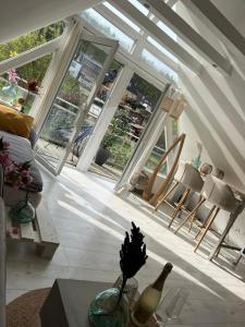 een woonkamer met ramen en een tafel en stoelen bij Moderner Altbau mit Infrarotsauna im Grünen in Witten