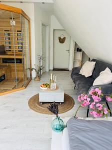 uma sala de estar com um sofá e uma mesa em Moderner Altbau mit Infrarotsauna im Grünen em Witten