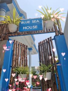a blue sea house sign on a building with plants at Blue Sea House Quảng Bình - Căn hộ 2 phòng ngủ, phòng khách và phòng bếp in Dong Hoi