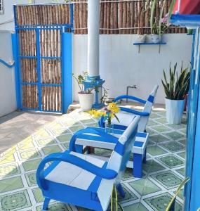 a patio with blue chairs and a table on a tile floor at Blue Sea House Quảng Bình - Căn hộ 2 phòng ngủ, phòng khách và phòng bếp in Dong Hoi