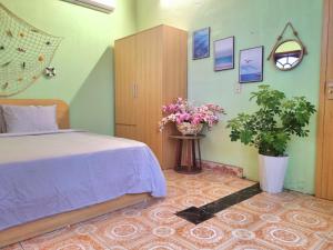 a bedroom with a bed and flowers on the wall at Blue Sea House Quảng Bình - Căn hộ 2 phòng ngủ, phòng khách và phòng bếp in Dong Hoi