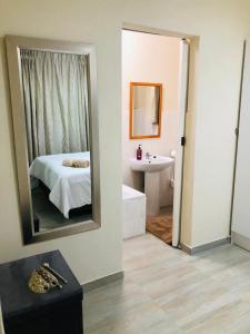 a bedroom with a bed and a mirror and a sink at Peshline Guest House Unit 3 in Ermelo