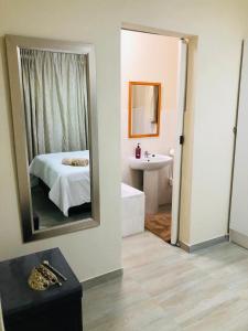 エルメロにあるPeshline Guest House Unit 3のベッドルーム(ベッド1台、鏡、シンク付)