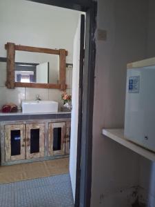 a kitchen with a sink and a mirror and a counter at Villa Bamboo Sumbawa in Sumbawa Besar