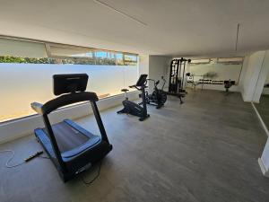 um ginásio com passadeiras e equipamento cardiovascular numa sala em Torres Blancas (Beach & Golf) em Alicante