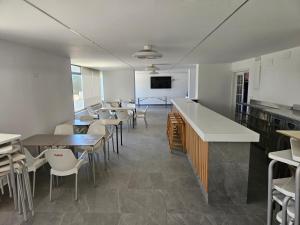 uma sala de jantar com mesas e cadeiras e uma televisão em Torres Blancas (Beach & Golf) em Alicante
