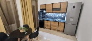 a kitchen with a stainless steel refrigerator and black chairs at Elena's Place, free parking!!! in Perea