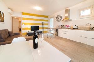 eine Küche und ein Wohnzimmer mit einer Flasche Wein auf dem Tisch in der Unterkunft Ferienwohnung für 4 Personen ca 70 m in Torri del Benaco, Gardasee Ostufer Gardasee in Torri del Benaco