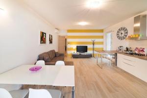 eine Küche und ein Wohnzimmer mit einem weißen Tisch und Stühlen in der Unterkunft Ferienwohnung für 4 Personen ca 70 m in Torri del Benaco, Gardasee Ostufer Gardasee in Torri del Benaco