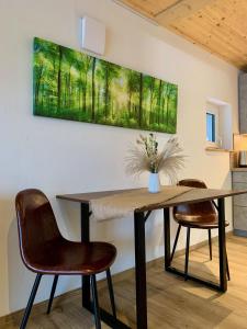 una mesa de comedor con sillas y una pintura en la pared en Raichberg Appartements en Hechingen