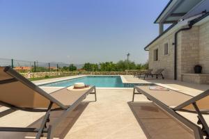 ein Swimmingpool mit zwei Stühlen und einem Tisch in der Unterkunft Ferienhaus für 8 Personen ca 200 qm in Šumber, Istrien Binnenland von Istrien in Šumber