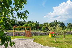 ein Spielplatz in einem Park mit einer Steinmauer in der Unterkunft Ferienhaus für 8 Personen ca 200 qm in Šumber, Istrien Binnenland von Istrien in Šumber