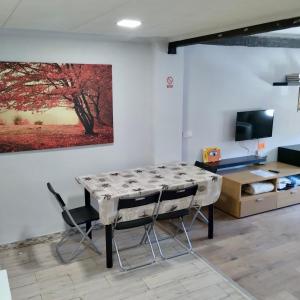 una mesa y sillas en una habitación con una pintura en Apartamentos FULL EQUIPPED, en Elche