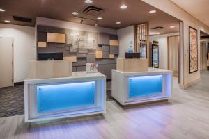 un vestíbulo de oficina con dos mostradores con pantallas azules en Holiday Inn Express & Suites - Aurora, an IHG Hotel en Aurora