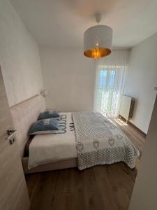 1 dormitorio con cama y lámpara de araña en La Casa di Nathalie, en Alvito