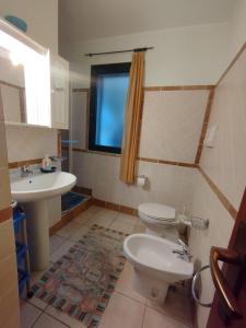 ein Bad mit einem WC, einem Waschbecken und einem Fenster in der Unterkunft Edera Apartment# Tanaunella# Budoni# Beach in Budoni