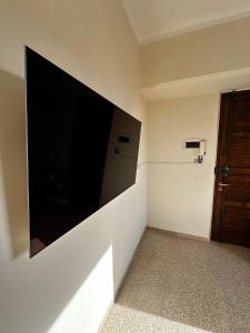 una grande TV a schermo piatto a parete in una camera di Casa in centro a Foligno