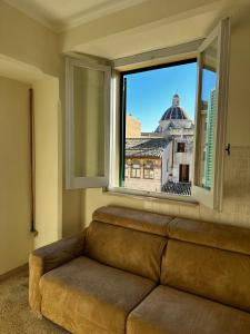 - un canapé installé devant une fenêtre avec vue dans l'établissement Casa in centro, à Foligno