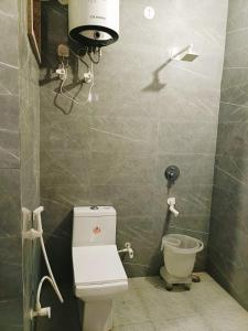 a bathroom with a toilet and a camera on the wall at Hotel AMBS suites A family Hotel Near Delhi Airport in New Delhi