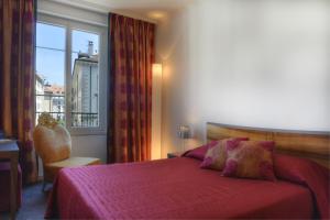 a bedroom with a red bed and a window at The Ambassador in Geneva