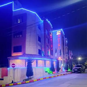 a building with lights on a street at night at سهول الكرمل للشقق الفندقية in Amman