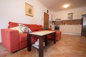 ein Wohnzimmer mit einem roten Sofa und einem Tisch in der Unterkunft Studio für 4 Personen ca 45 qm in Novigrad, Istrien Istrische Riviera - b59060 in Karpinjan