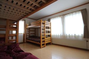 a bedroom with bunk beds and a large window at ゲストハウス樹舎 in Minami-jūichijō