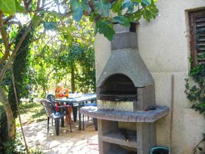 un horno de pizza al aire libre junto a una mesa en Ferienwohnung für 8 Personen ca 100 qm in Pula, Istrien Istrische Riviera, en Pula