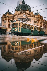 a train is parked in front of a building at D114 Victorian Central Stay in Melbourne