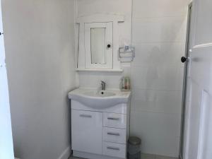 a white bathroom with a sink and a shower at D114 Victorian Central Stay in Melbourne