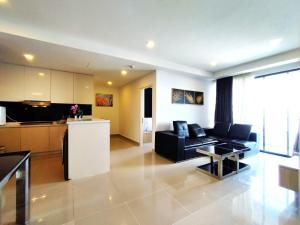 a living room with a couch and a kitchen at GentingTop SunriseColdSty2R2B8Pax at GrdIonDelmn in Genting Highlands