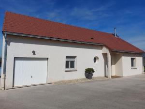a large white garage with a red roof at Entre Lacs Et Montagnes , Maison individuelle,lits préparés, parking et ménage inclus in Barésia-sur-lʼAin