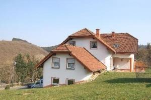 una casa blanca con techos rojos en una colina en Ferienwohnung für 6 Personen ca 68 qm in Daun-Weiersbach, Rheinland-Pfalz Moseleifel en Daun