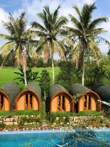 a row of houses with palm trees in the background at BUNGALOW DANANG Healing Homestay 