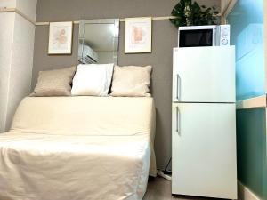 a room with a refrigerator with a microwave on top at COCO Nakameguro302 in Tokyo