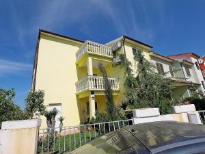 ein gelbes Haus mit einem Balkon an der Seite in der Unterkunft Studio für 7 Personen ca 80 qm in Stinjan, Istrien Istrische Riviera in Štinjan