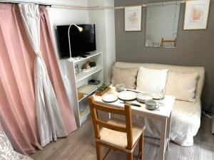 un soggiorno con tavolo e divano di COCO Nakameguro302 a Tokyo