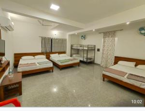 DharmastalaBougainvillea Residency的一间有三张床的房间