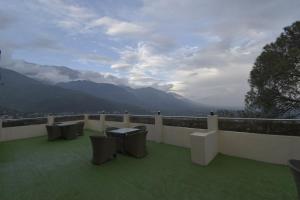a balcony with chairs and a view of the mountains at Sawaya Guest House in Mount Ābu
