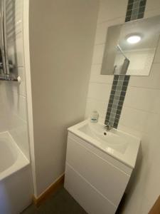 La salle de bains blanche est pourvue d'un lavabo et d'une douche. dans l'établissement Apt 7 Cathedral & River view, à Norwich