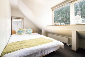 a small bedroom with a bed and a window at The BASE in Otaru