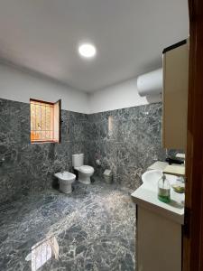 a bathroom with two toilets and a sink at Vila Murati in Tirana