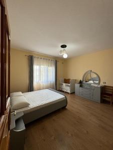 a bedroom with a bed and a dresser at Vila Murati in Tirana