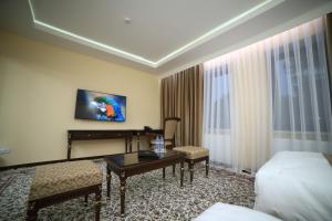 a hotel room with a bed and a table and a desk at GREAT SILK ROAD HOTEL in Fergana