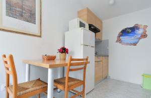 a small kitchen with a table and a refrigerator at Ferienwohnung für 2 Personen ca 20 qm in Pula, Istrien Istrische Riviera - b54951 in Pula