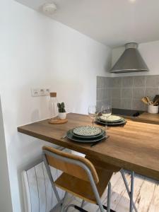uma cozinha com uma mesa de madeira e copos de vinho em L’Oliveraie du Revest em Le Revest-le-Eaux