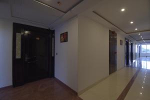 a hallway with a black door and a white wall at Gourav Lodge in Jodhpur