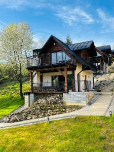 a log home with a large porch and balcony at Domki Pienińskie Tarasy in Szczawnica