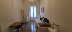 Habitación pequeña con cama, escritorio y ventana. en Dimora Manzoni en Busto Arsizio